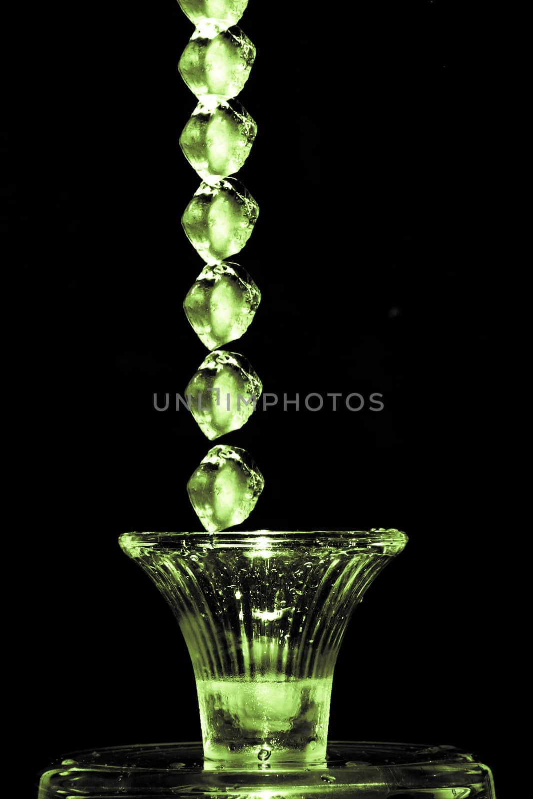 Stroboscopic effect created using flash capturing the motion ice as it splashes into a glass