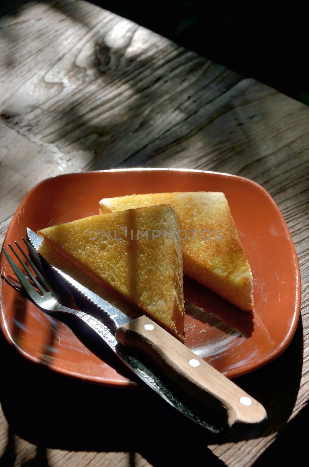 Buttered toast with morning light by pixbox77