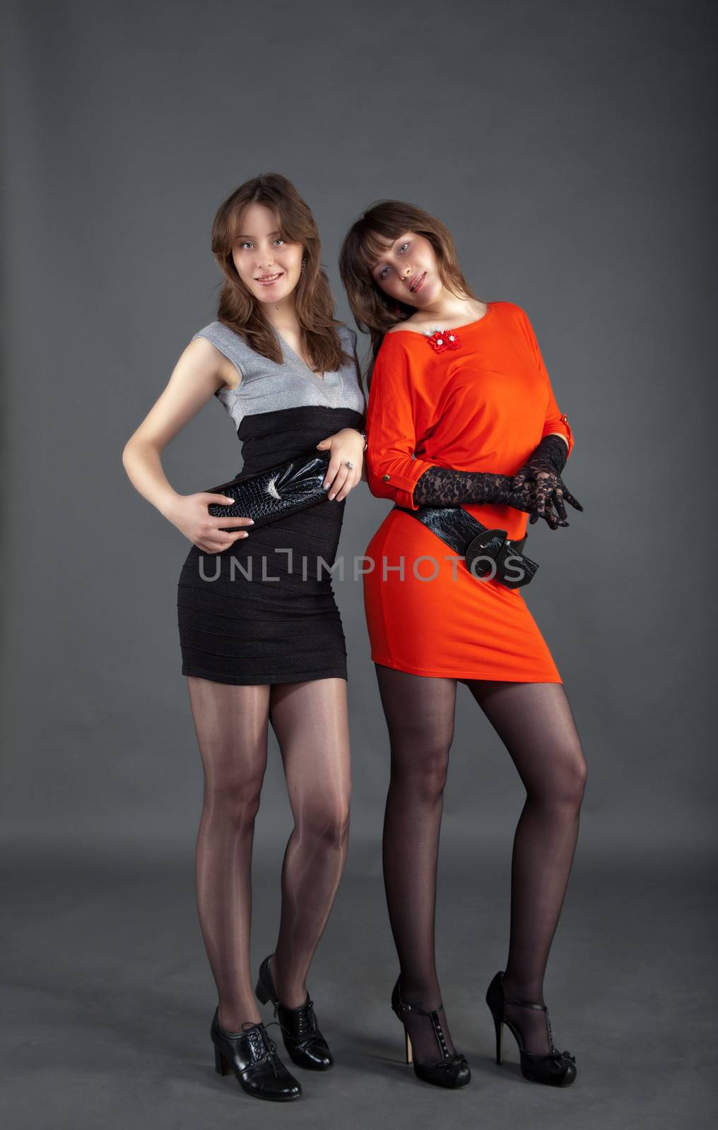 two young pretty girls posing staying in studio