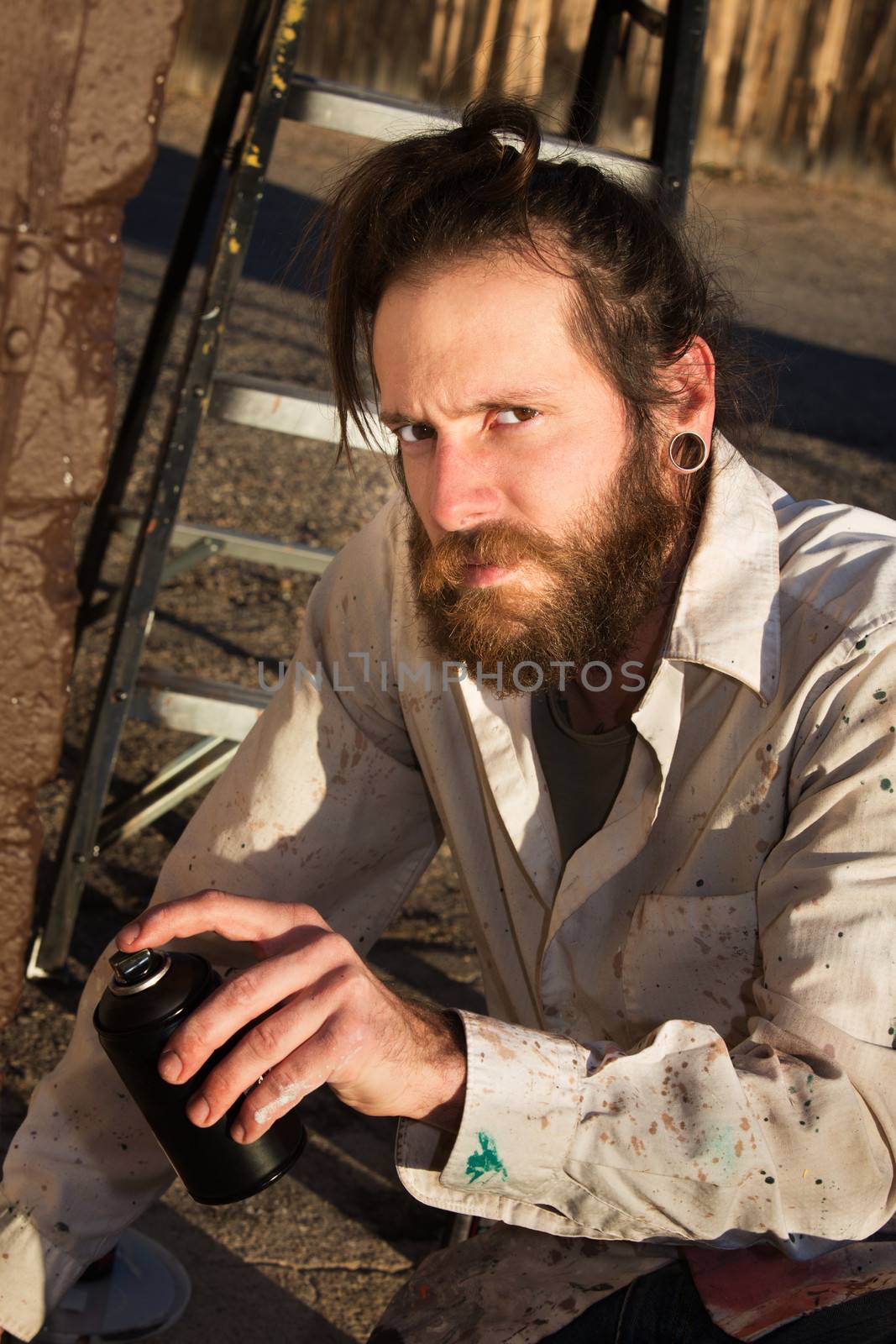 Single graffito artist spray painting a wall outdoors