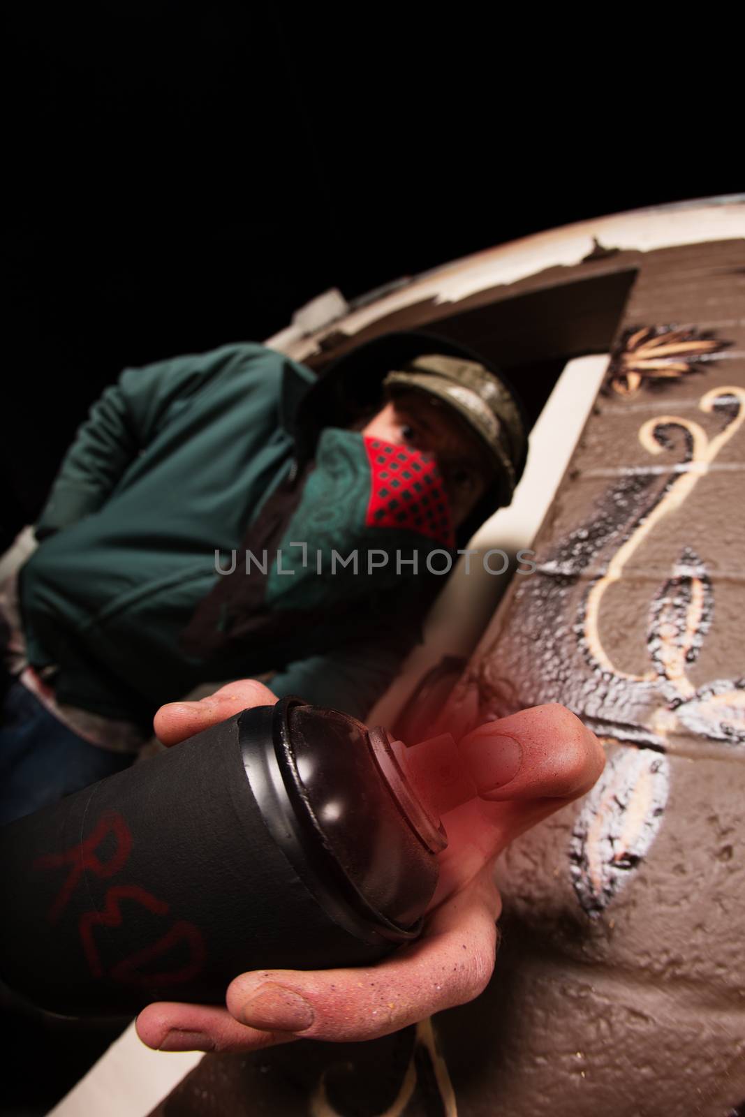 Man hiding behind face mask with spray paint can