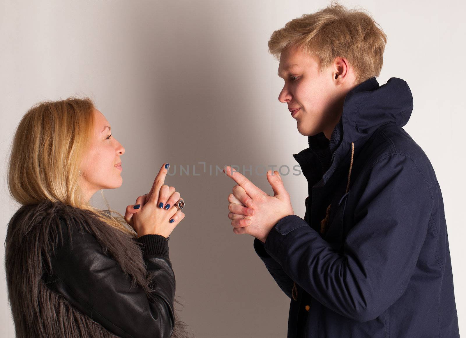 Caucasian blonde couple having fun with fingers up like a guns