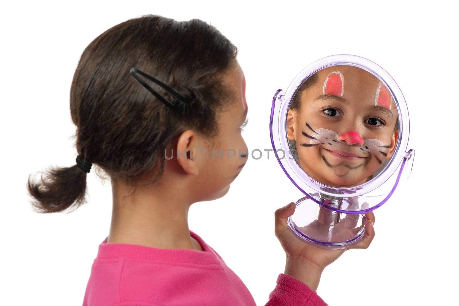 A young girl looks at herself in the mirror after her facial painting.