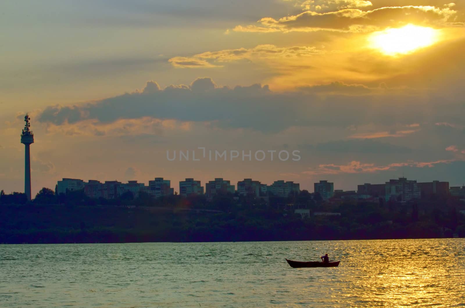 fishermen in boat at sunset on danube river