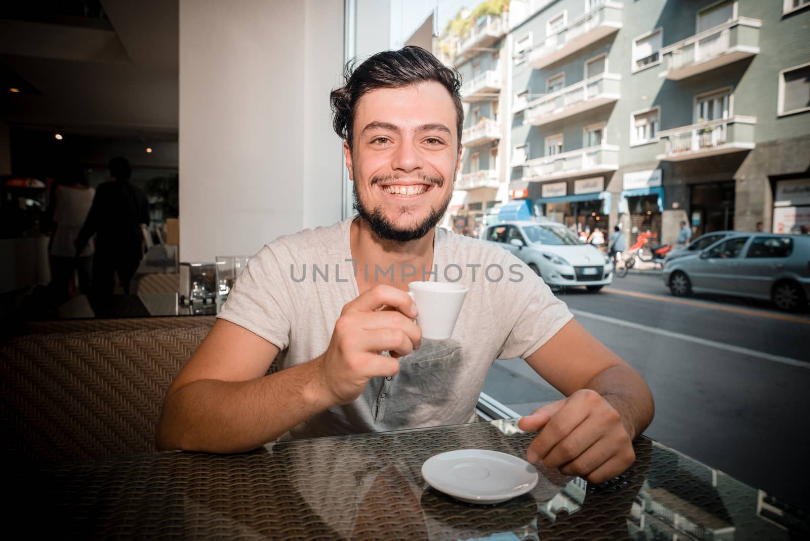 young stylish man drinking coffee in a bar