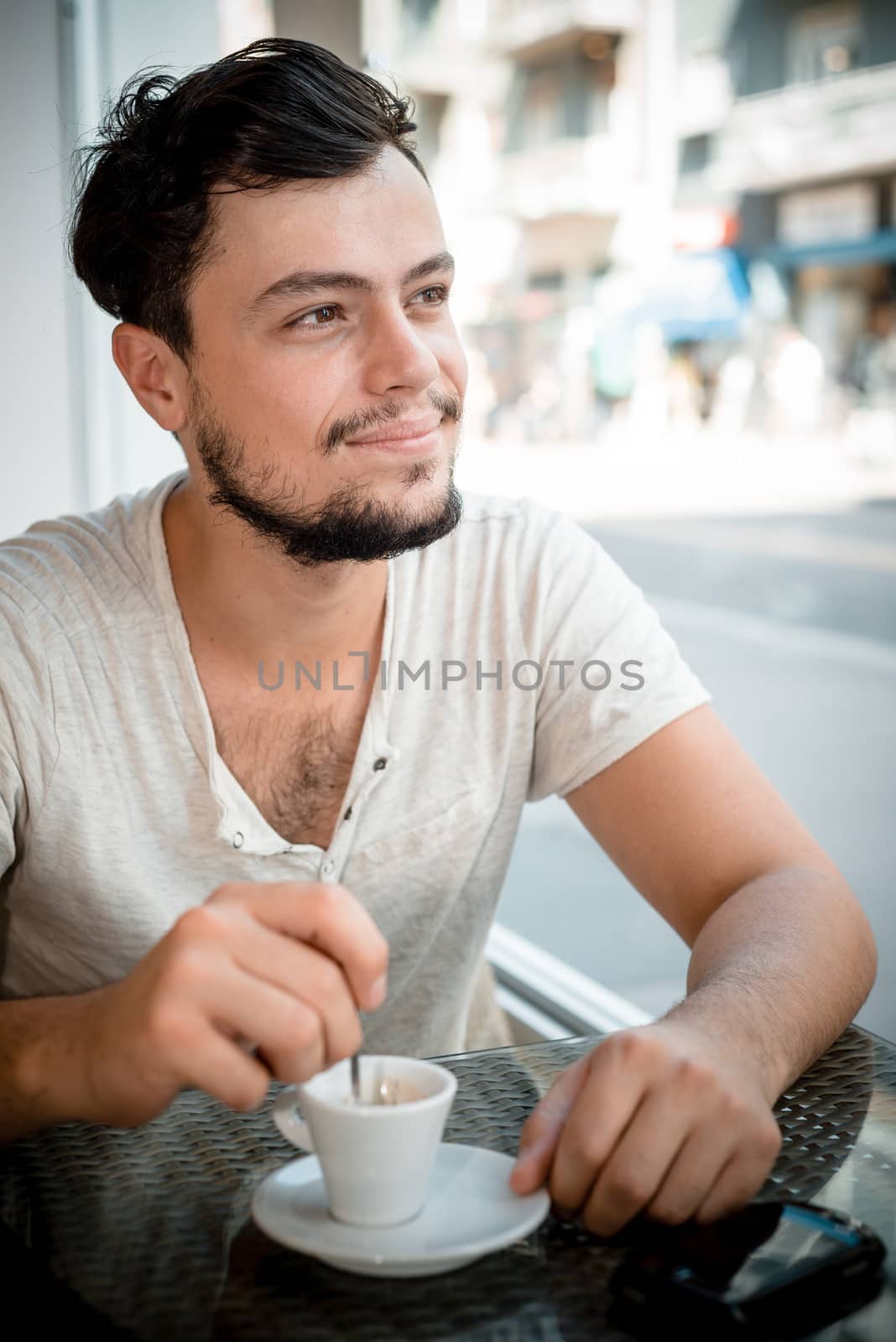 young stylish man drinking coffee in a bar