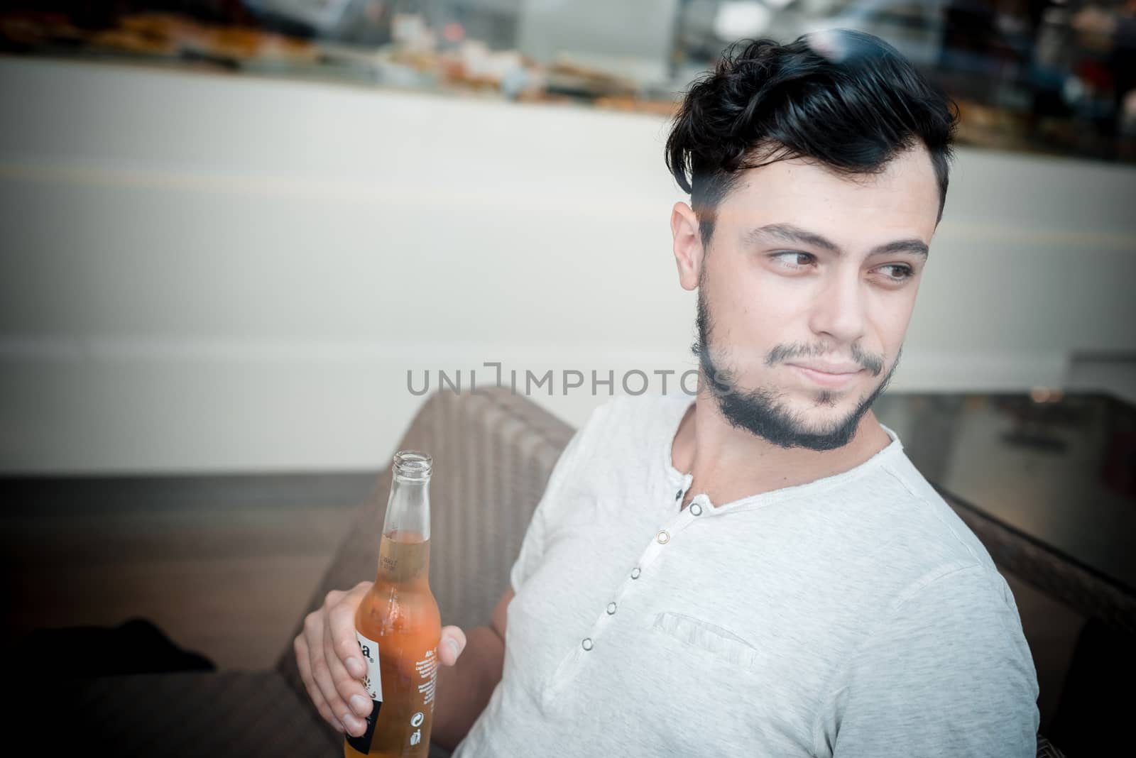 young stylish man drinking beer in a bar