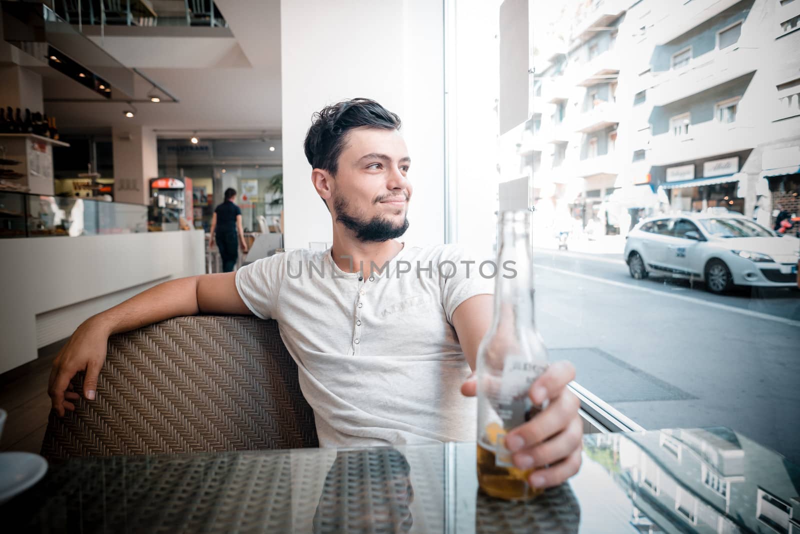 young stylish man drinking beer in a bar