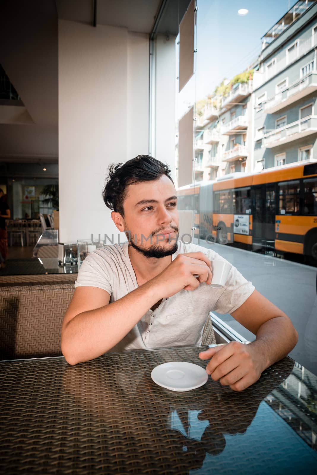 young stylish man drinking coffee by peus