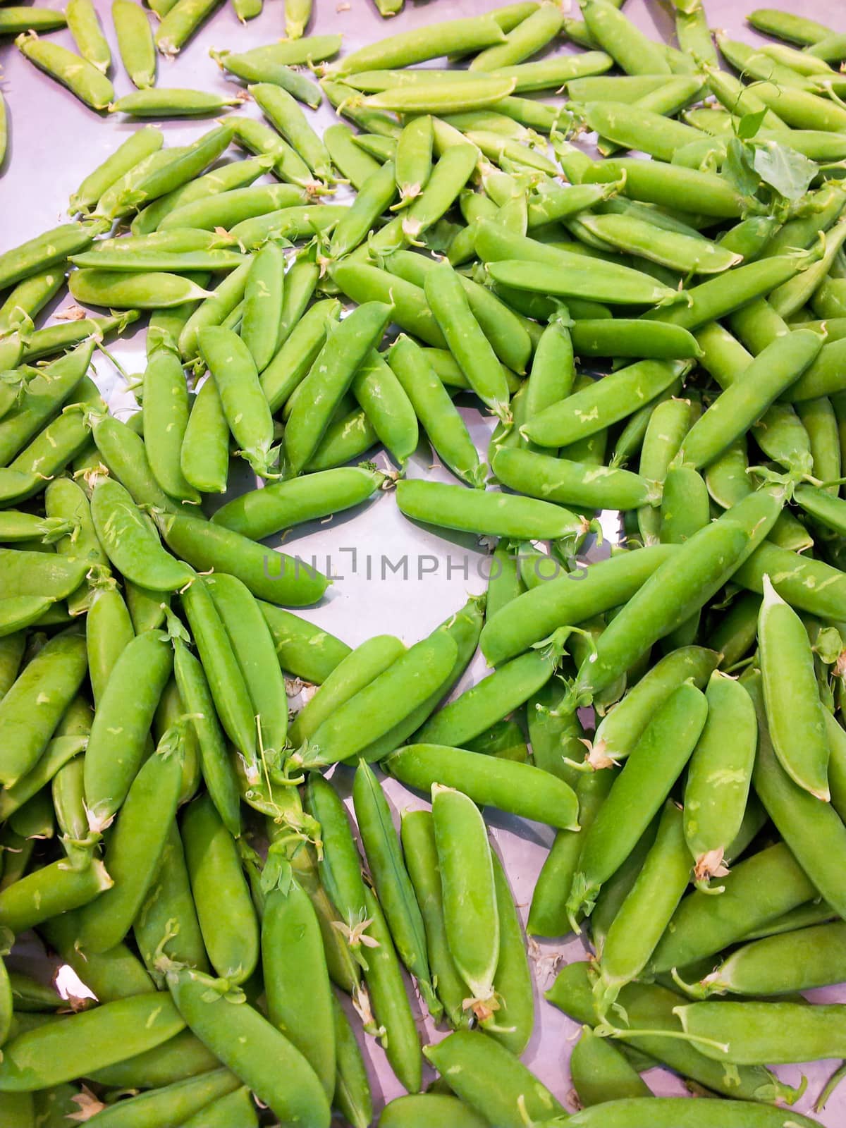Pile of green beans in a tray with white paper, at a marketplace