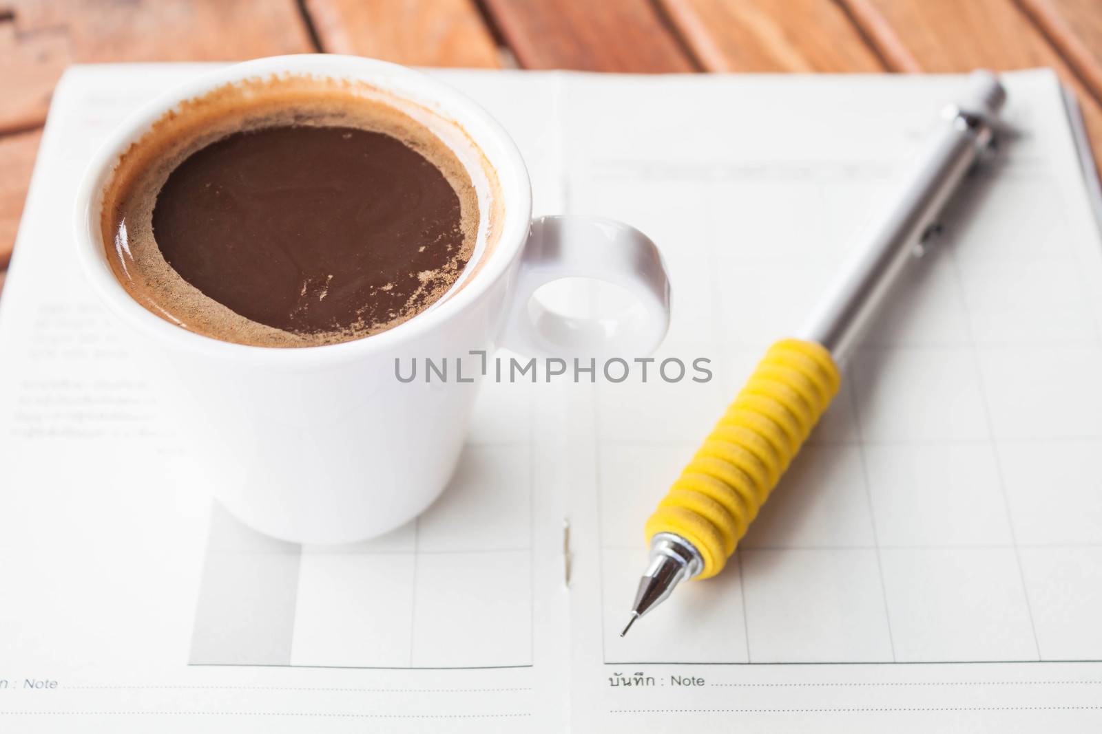 White cup of espresso on work wood table