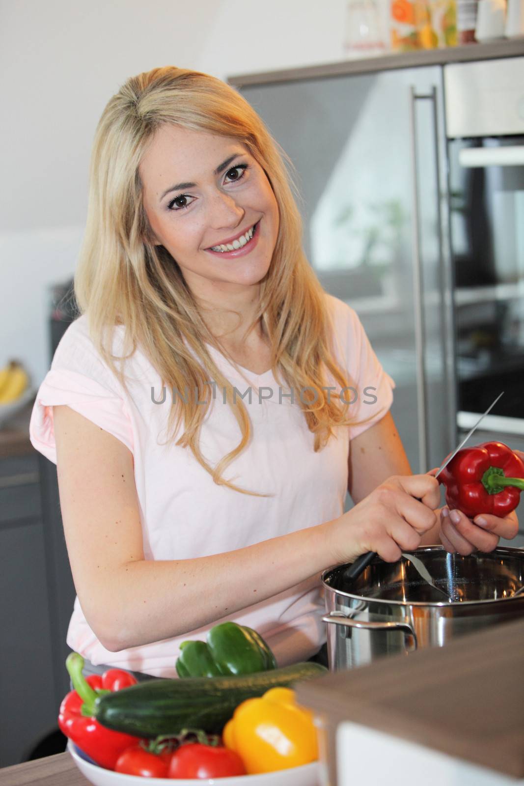 Smiling woman preparing a meal by Farina6000