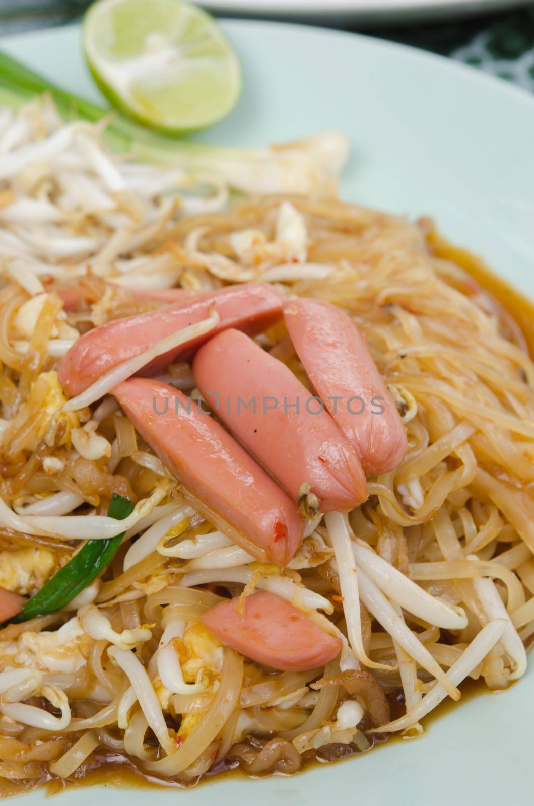  stir fried  noodles with sausage ,  egg  and vegetable on dish , asian style noodles