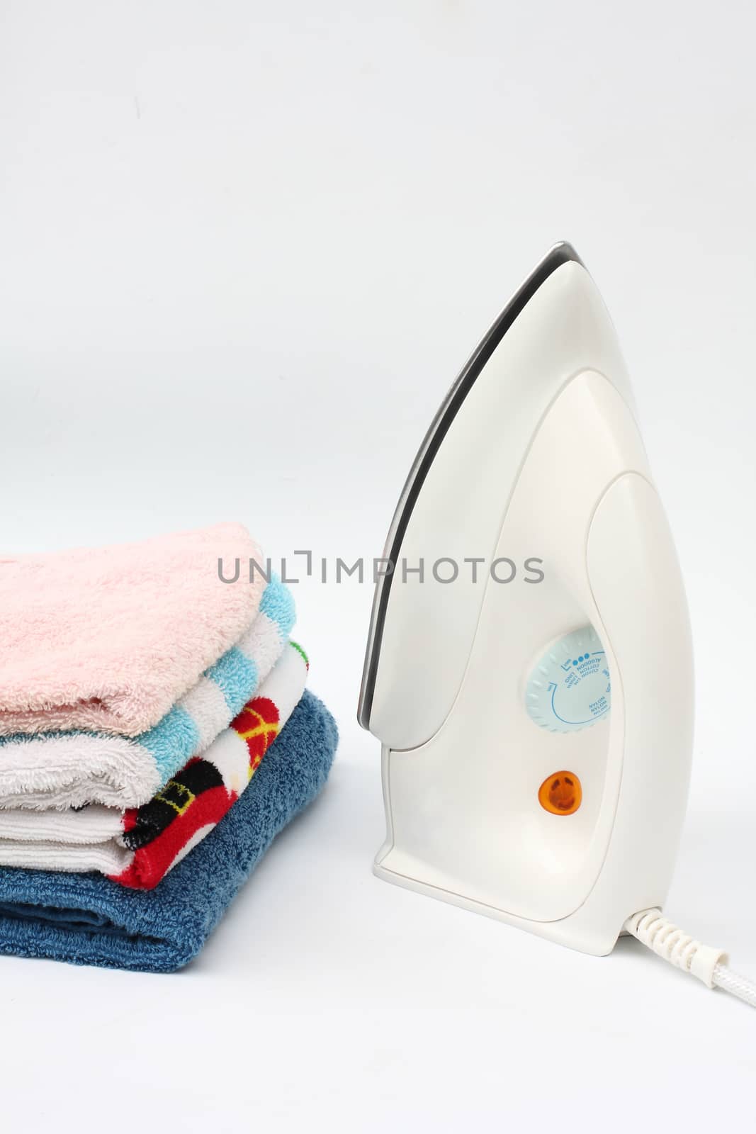 Pile of colorful clothes and electric iron on white background by myrainjom01