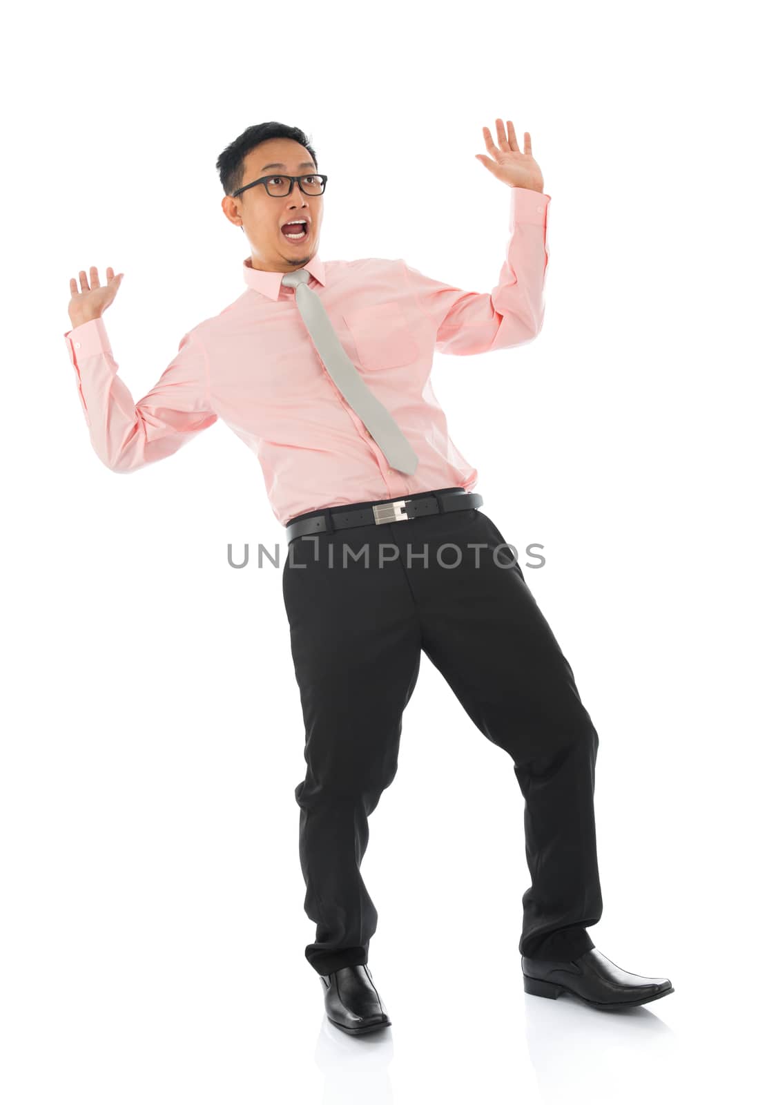 Full body shocked young Asian businessman open arms body bend backwards, isolated on white background