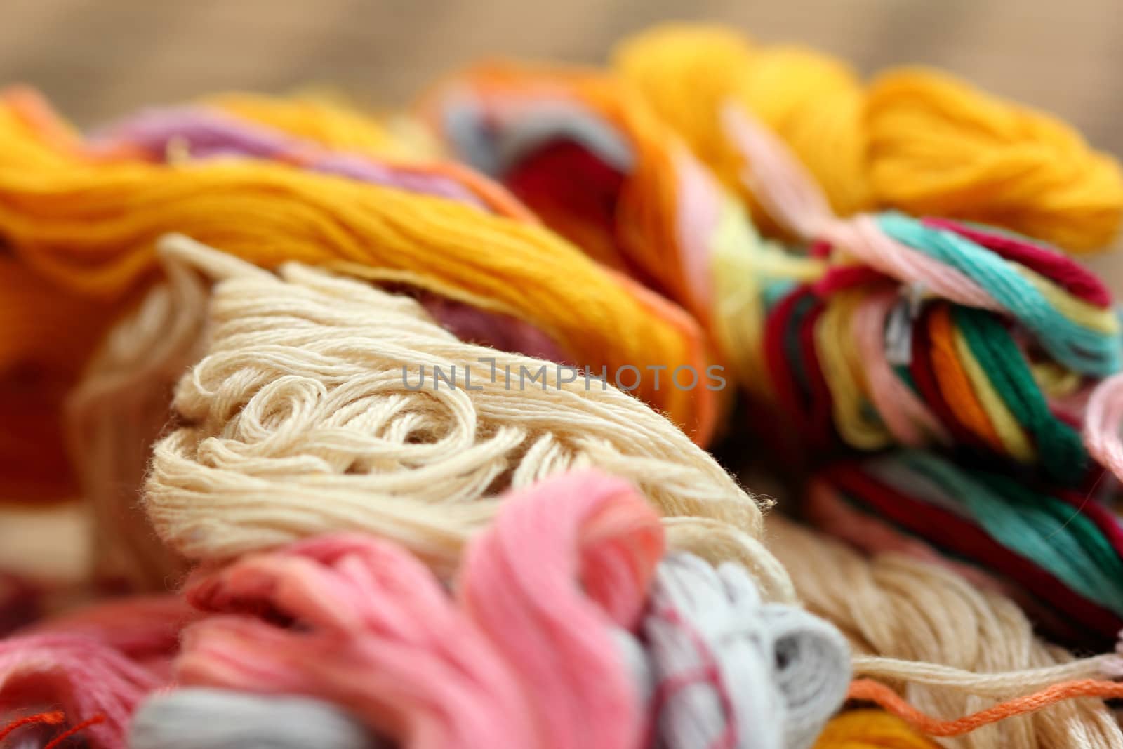 a tangle of colored threads for embroidery and needle