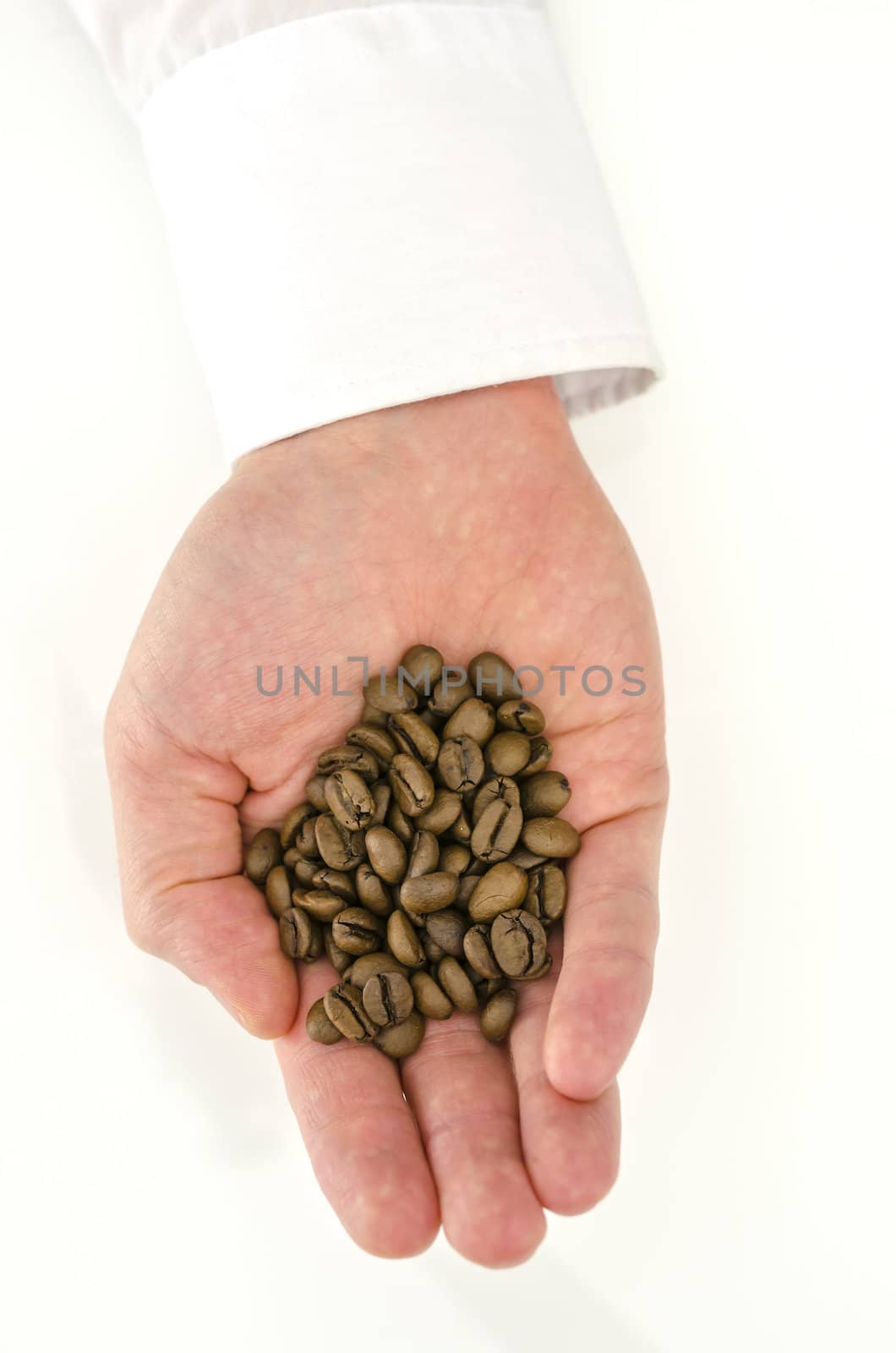 Top view of male hand holding coffee beans.
