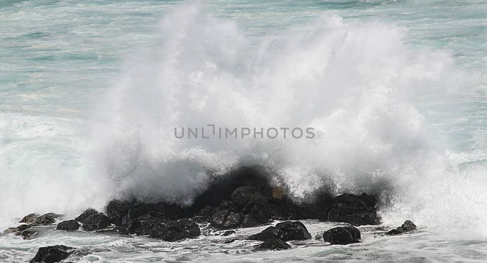 close-up of a wave crashing over rocks