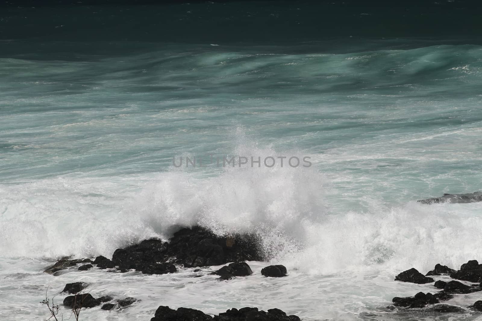 close-up of a wave crashing over rocks