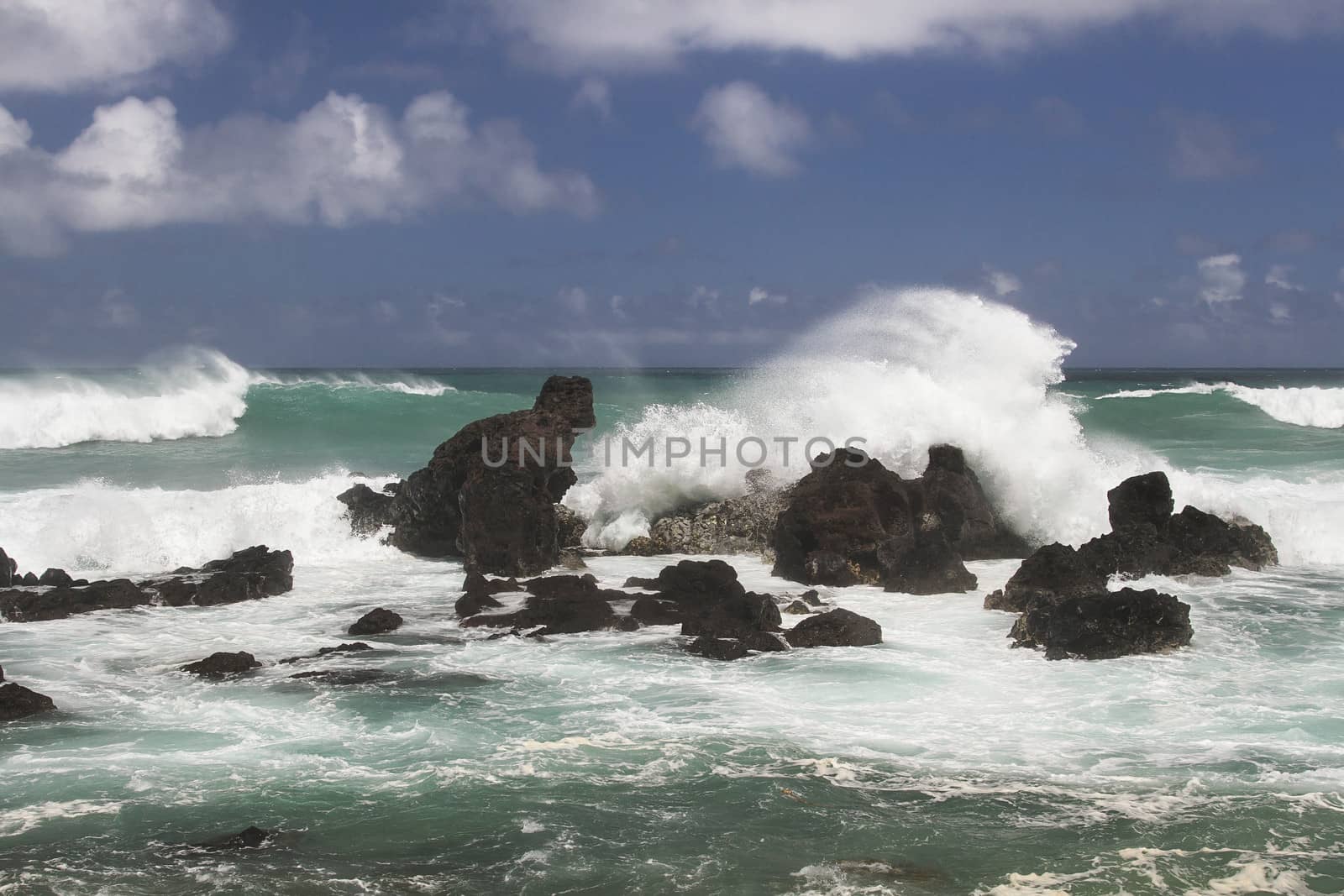 volcanic rock formation being pounded by wave