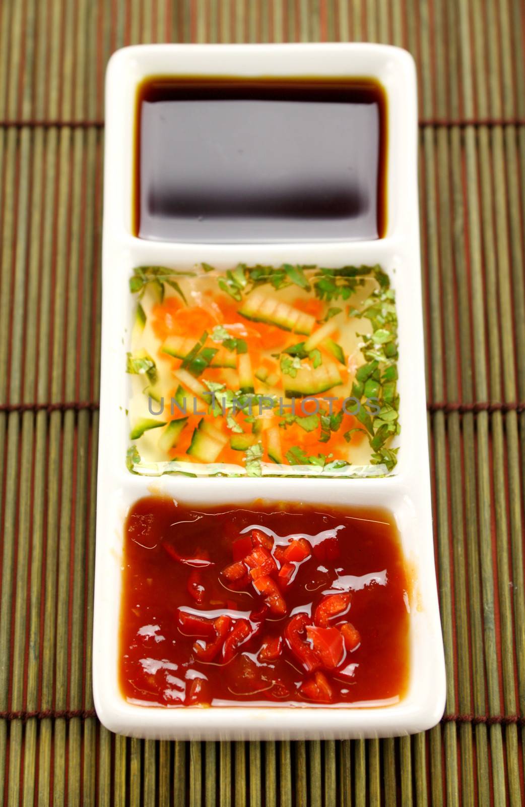 Asian dipping sauces consisting of chillie sauce, soy sauce and cucumber and parsley sauce.