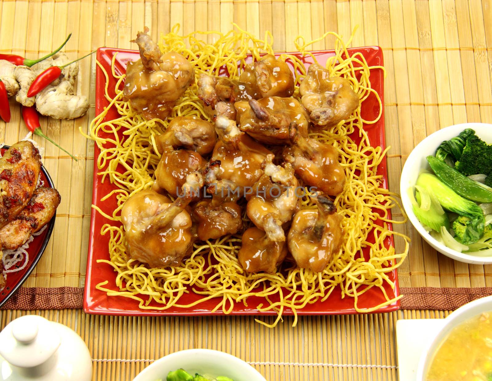 Asian honey and soy chicken drumettes with a rich sauce on crispy noodles.