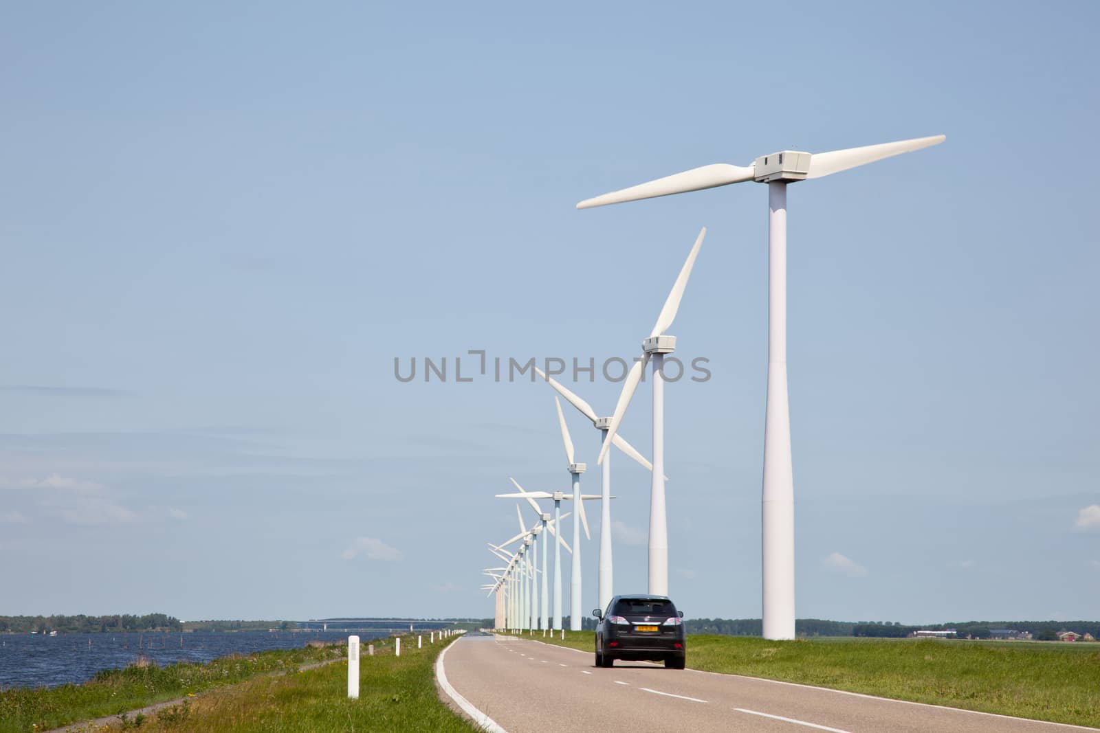 row of wind turbines and car by ahavelaar