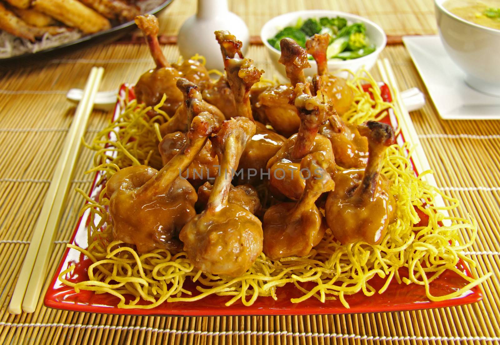 Asian honey and soy chicken drumettes with a rich sauce on crispy noodles.