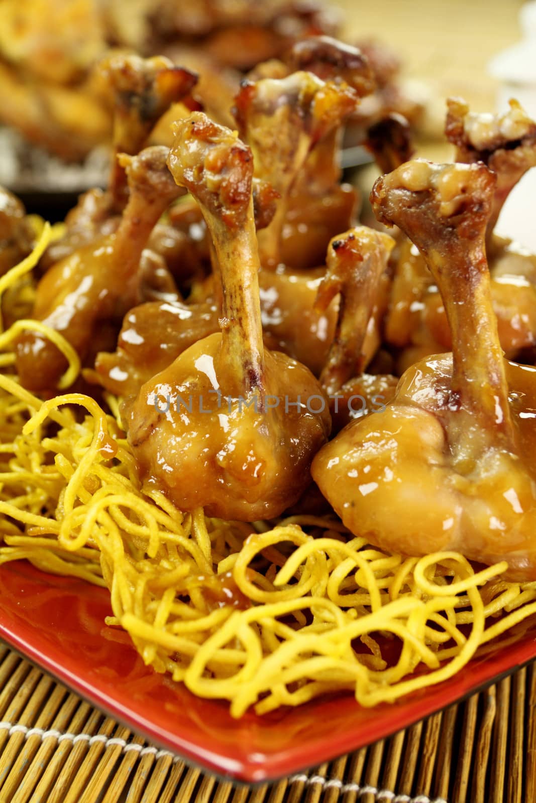 Delicious Chinese chicken drumettes on a bed of noodles.