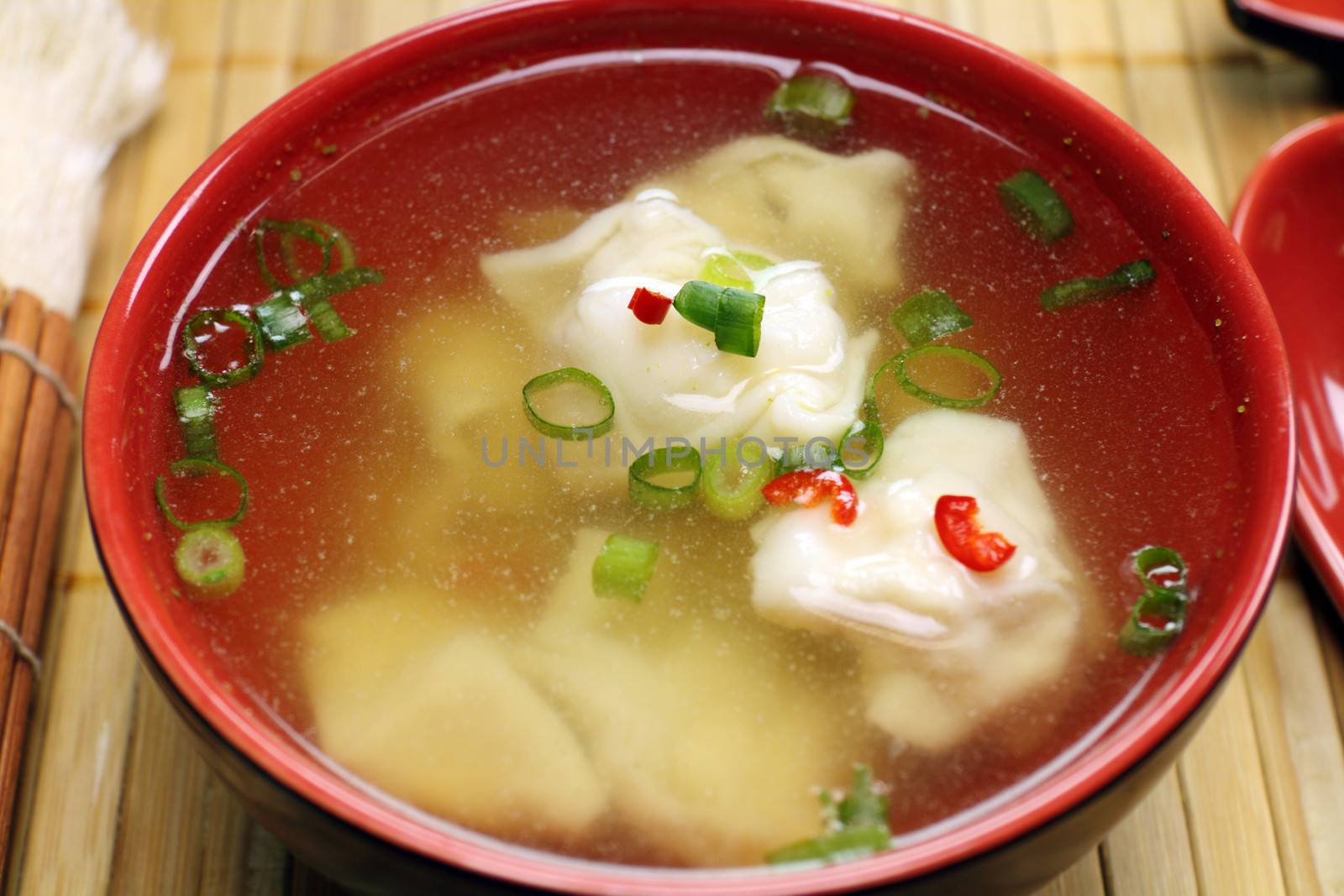 Delicious Chinese short soup with dumplings and diced shallots.