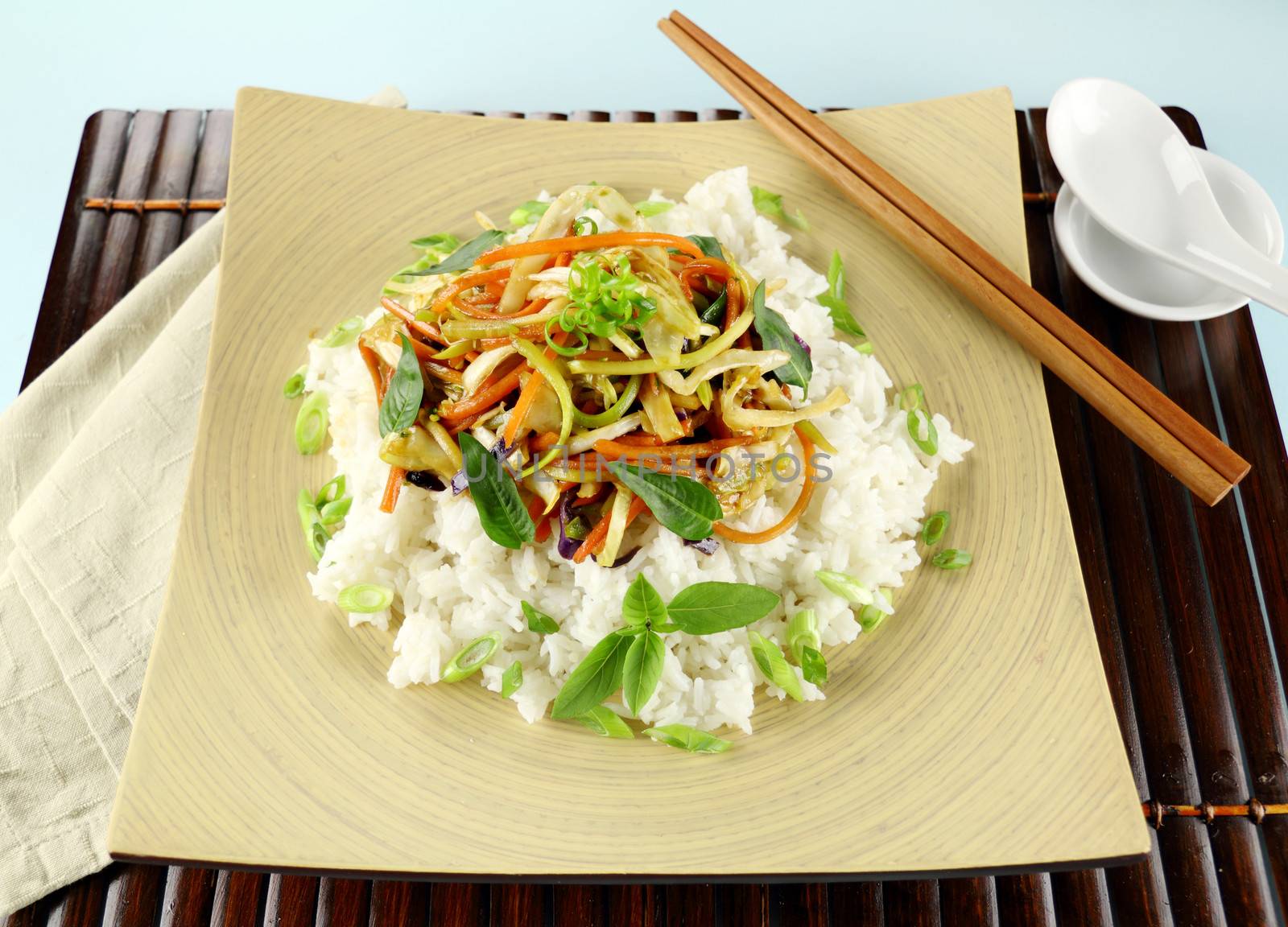 Delicious vegetarian asian stir fry on boiled white rice with thai basil and vietnamese mint.