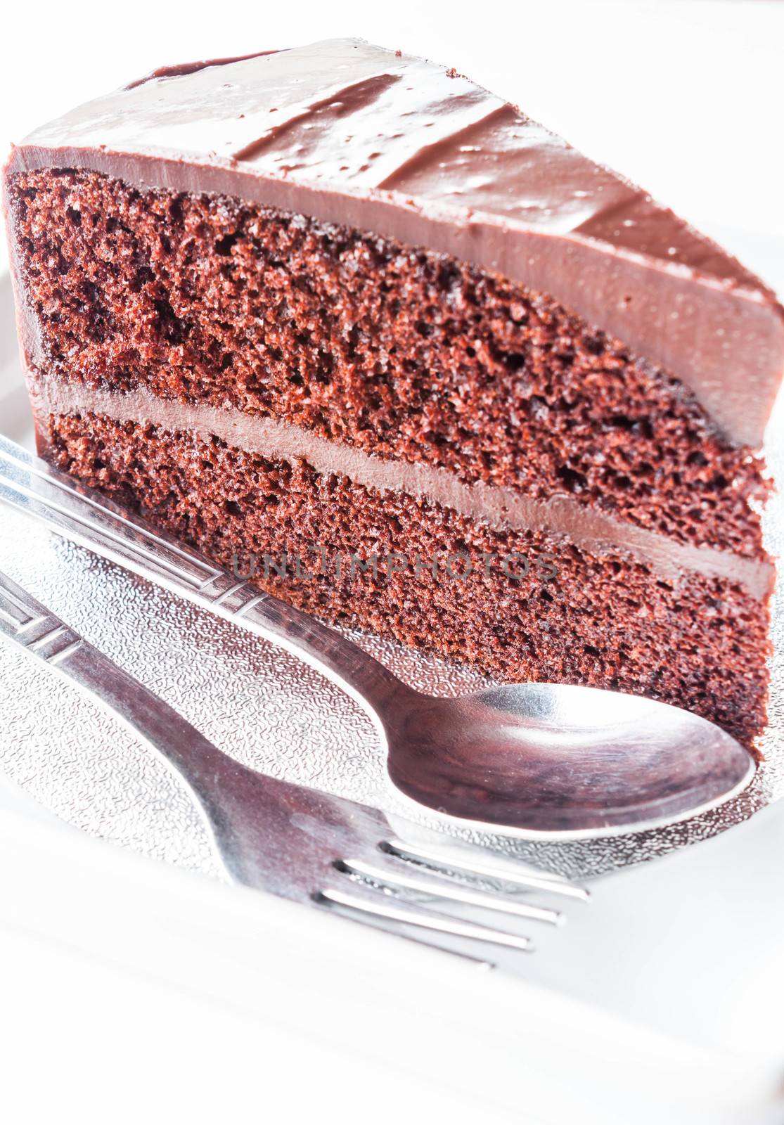 Piece of chocolate cake with spoon and fork
