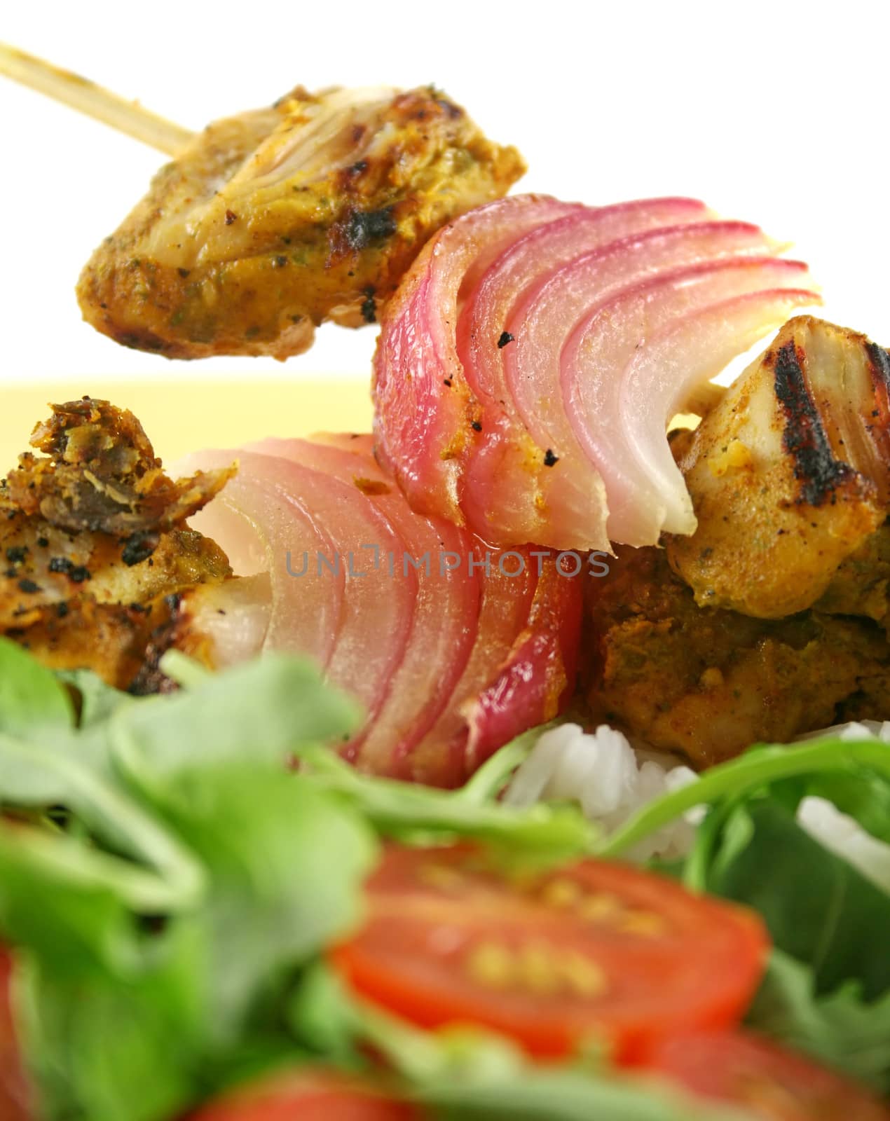 Chicken tandoori skewers with red onion and a rocket salad.