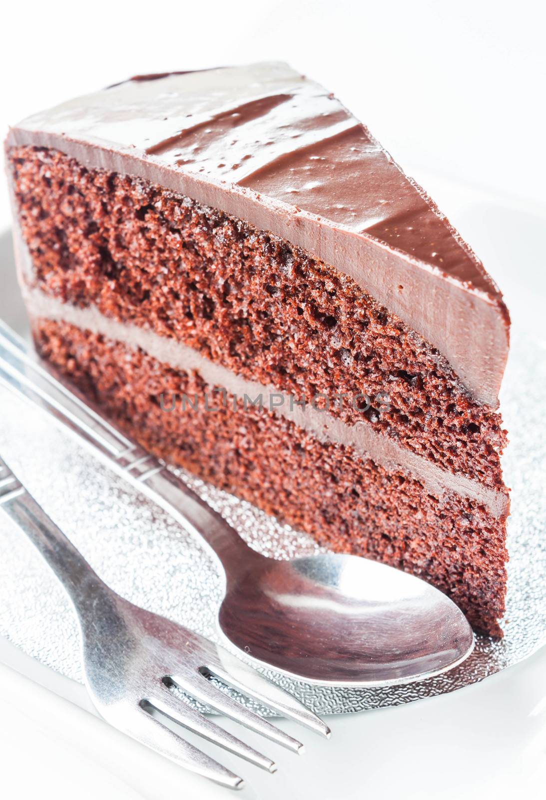 Close up piece of chocolate cake with spoon and fork