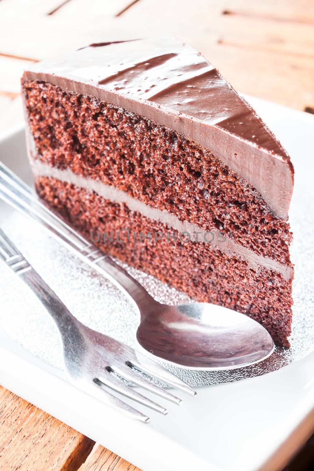 Piece of chocolate cake serving with spoon and fork  by punsayaporn