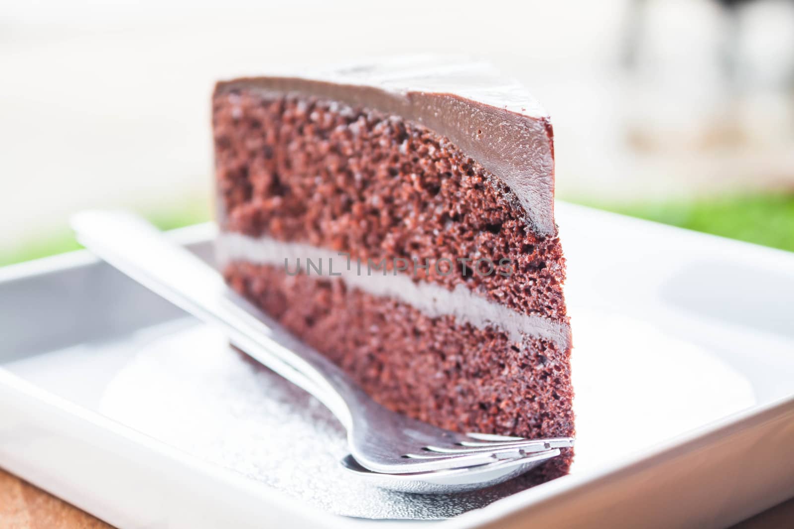 Chocolate custard cake serving with spoon and fork by punsayaporn