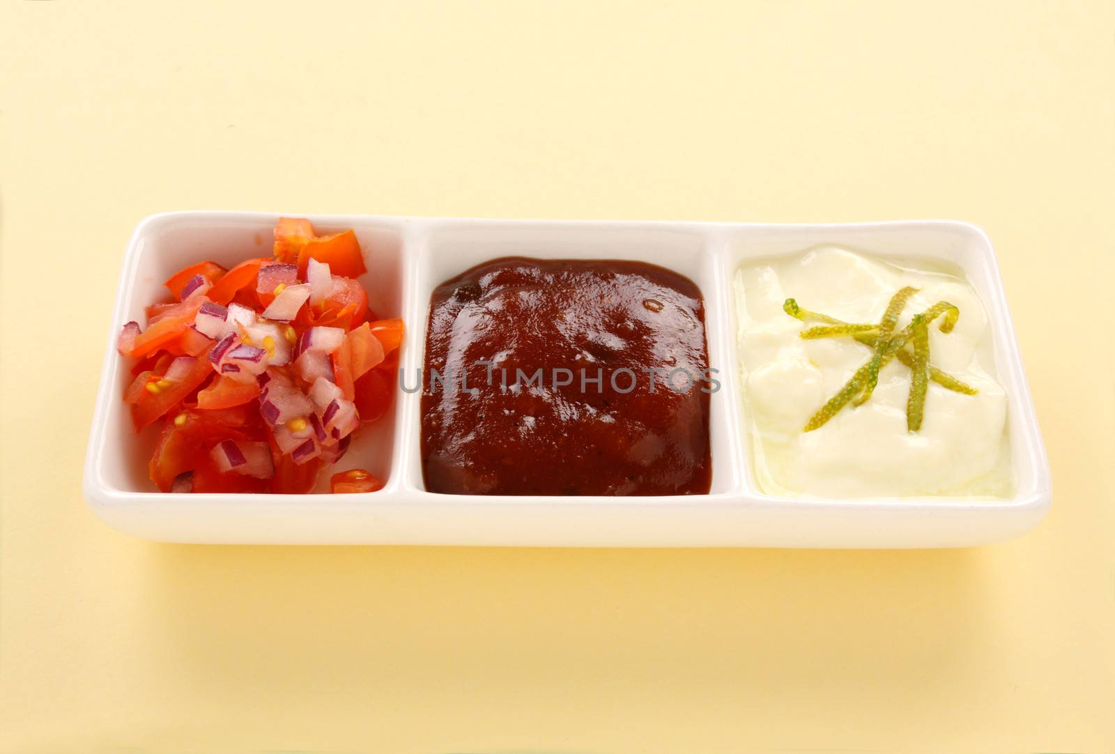 Indian condiments consisting of yoghurt and lime, chutney and tomato and onion.