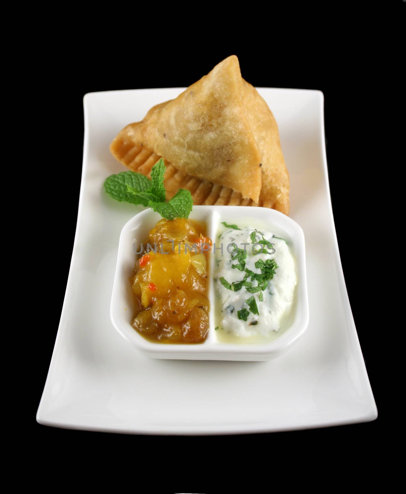 Indian samosa with mango chutney and herb yogurt.