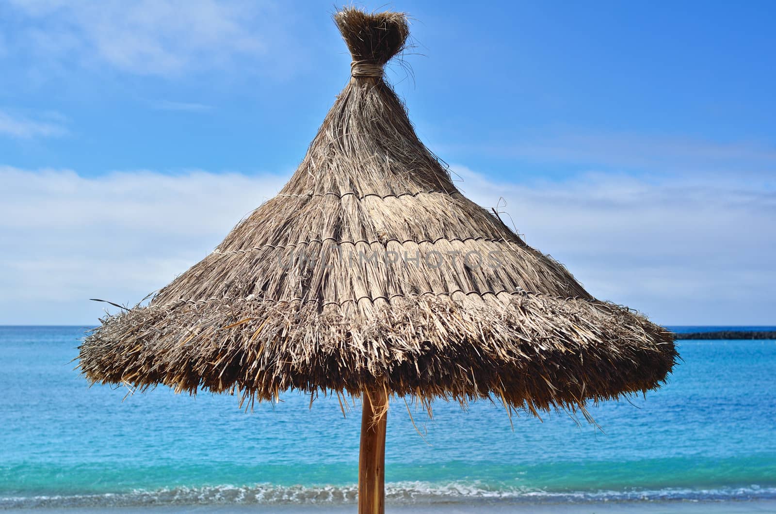 Straw parasol on a beautiful tropical beach