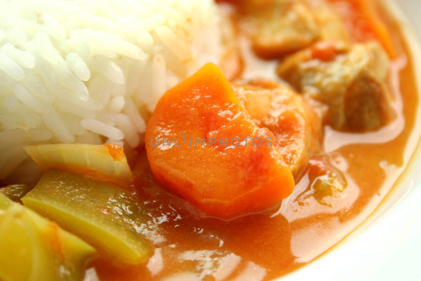 Close up of carrot in a delicious chicken gumbo with rice.