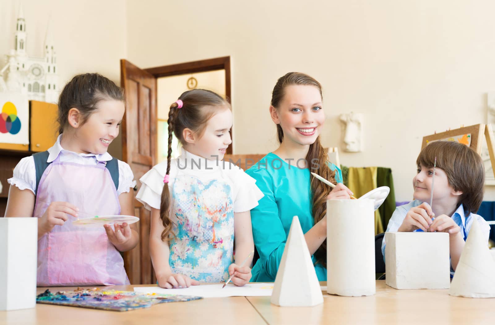 children draw with the teacher in the classroom drawing