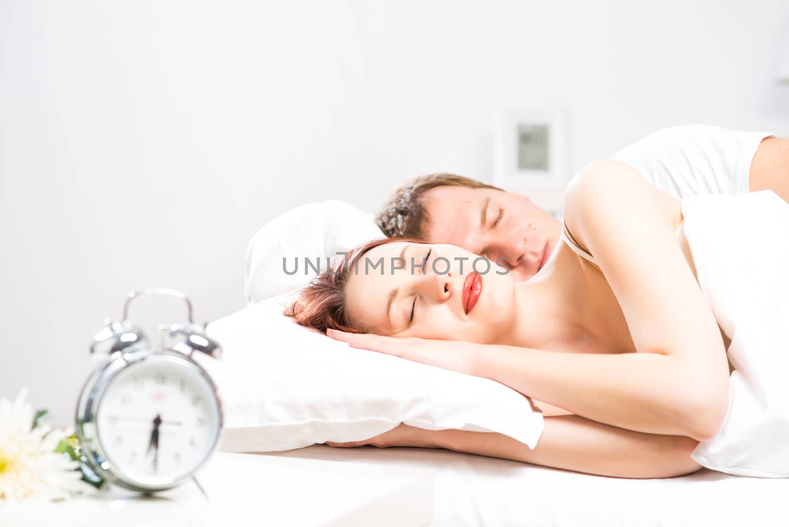 young beautiful woman sleeping on the bed with her husband