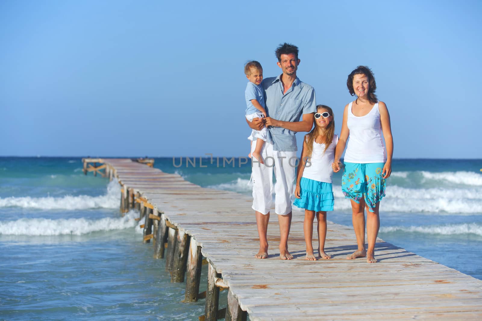 Family on wooden jetty. by maxoliki