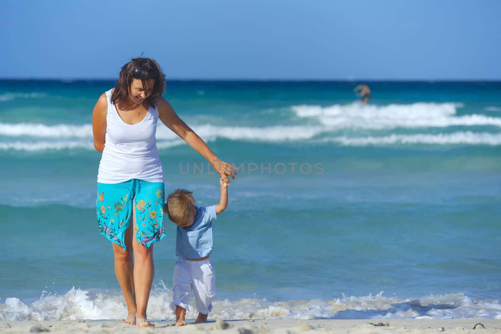 Happy beautiful mother and son enjoying beach time