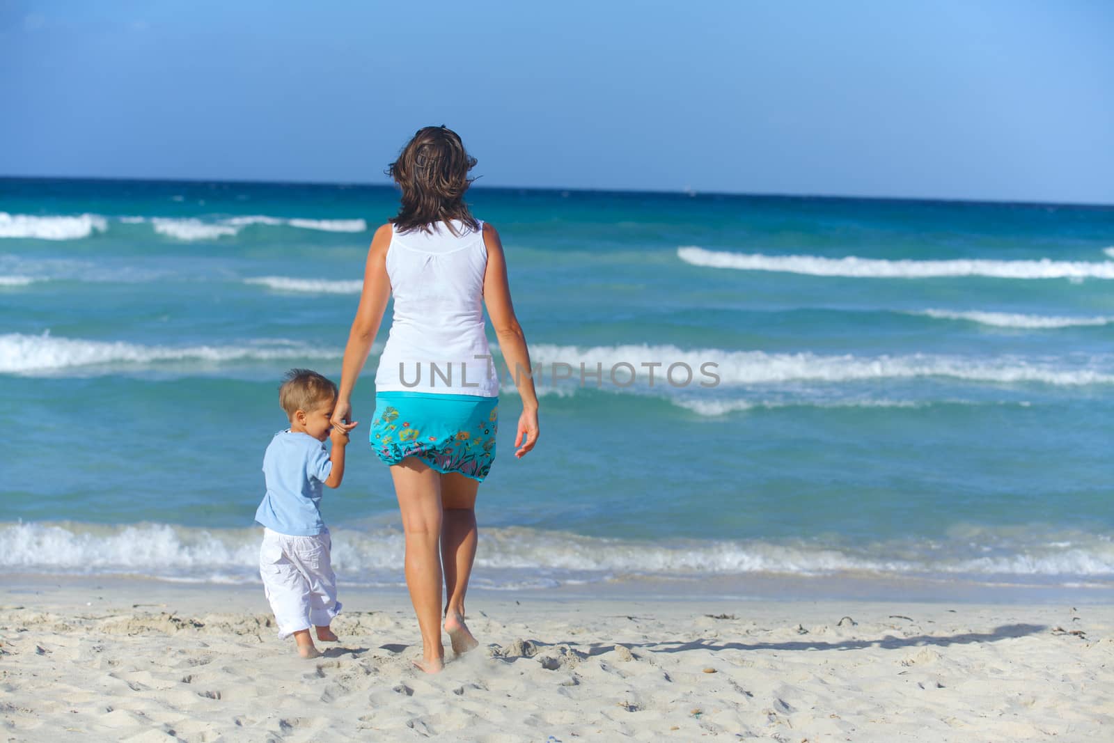 Happy beautiful mother and son looking on the sea.