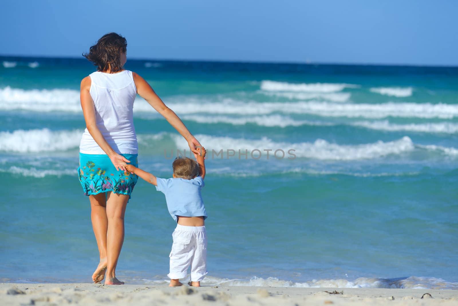 Happy beautiful mother and son enjoying beach time