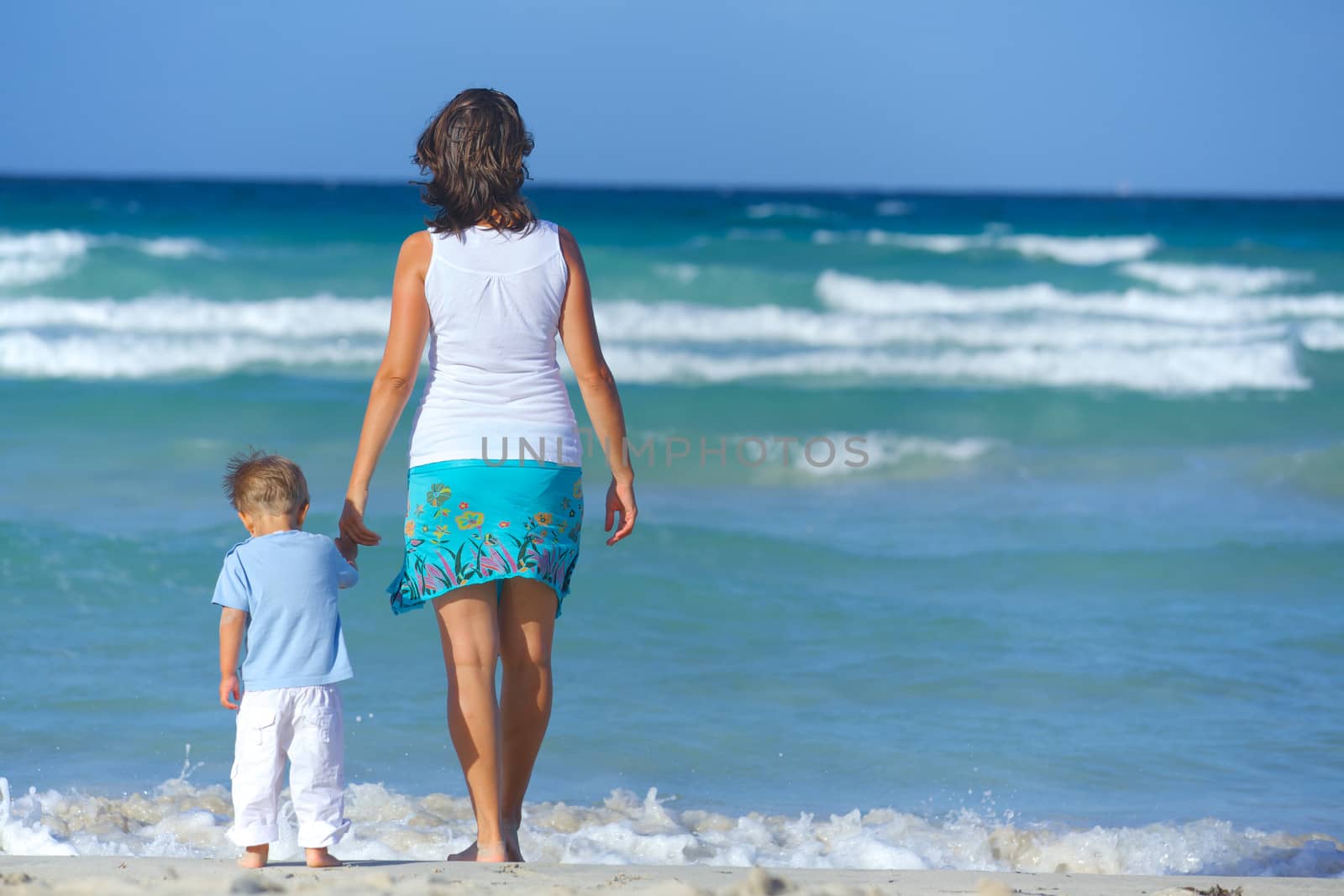 Happy beautiful mother and son looking on the sea.