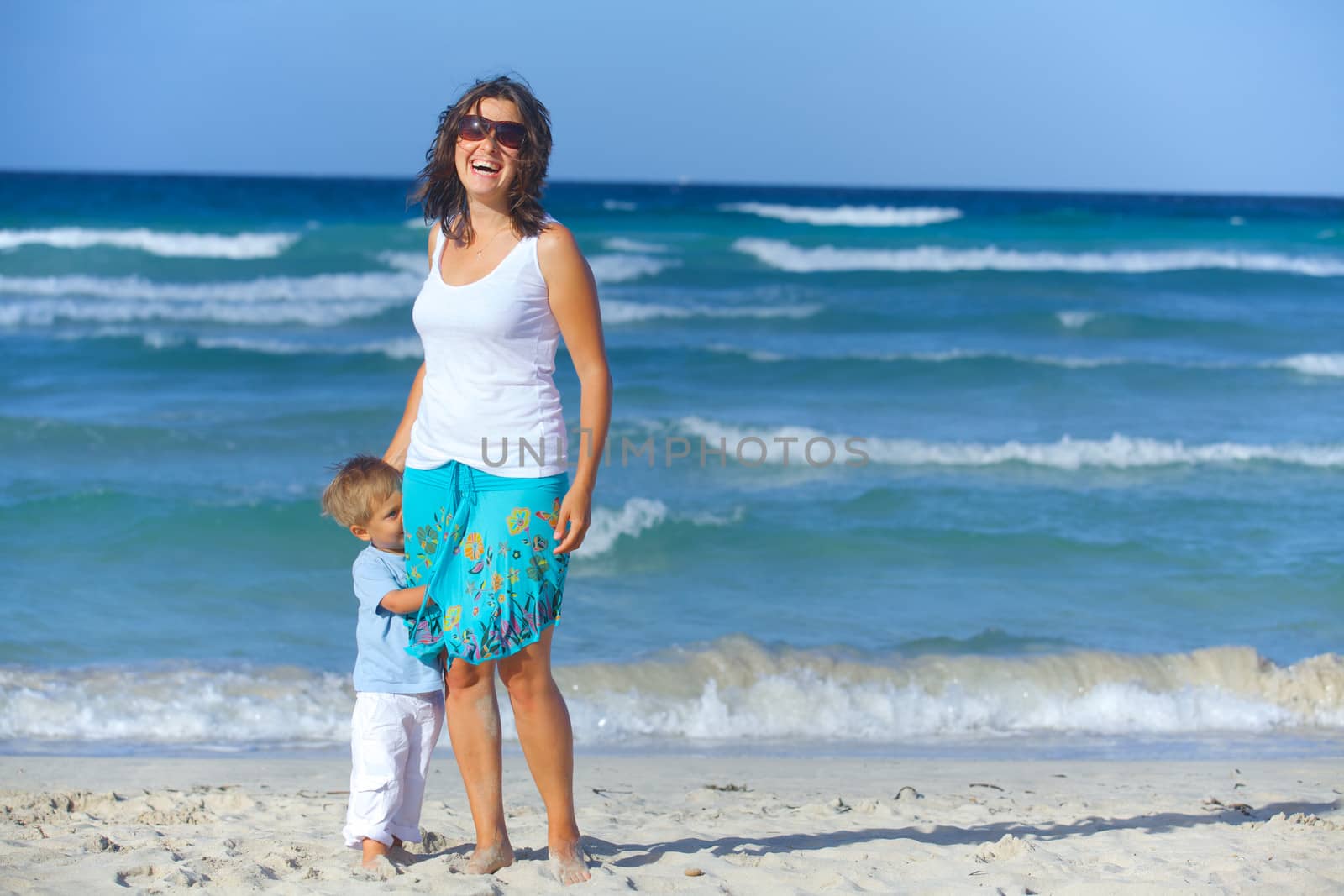 Happy beautiful mother and son enjoying beach time