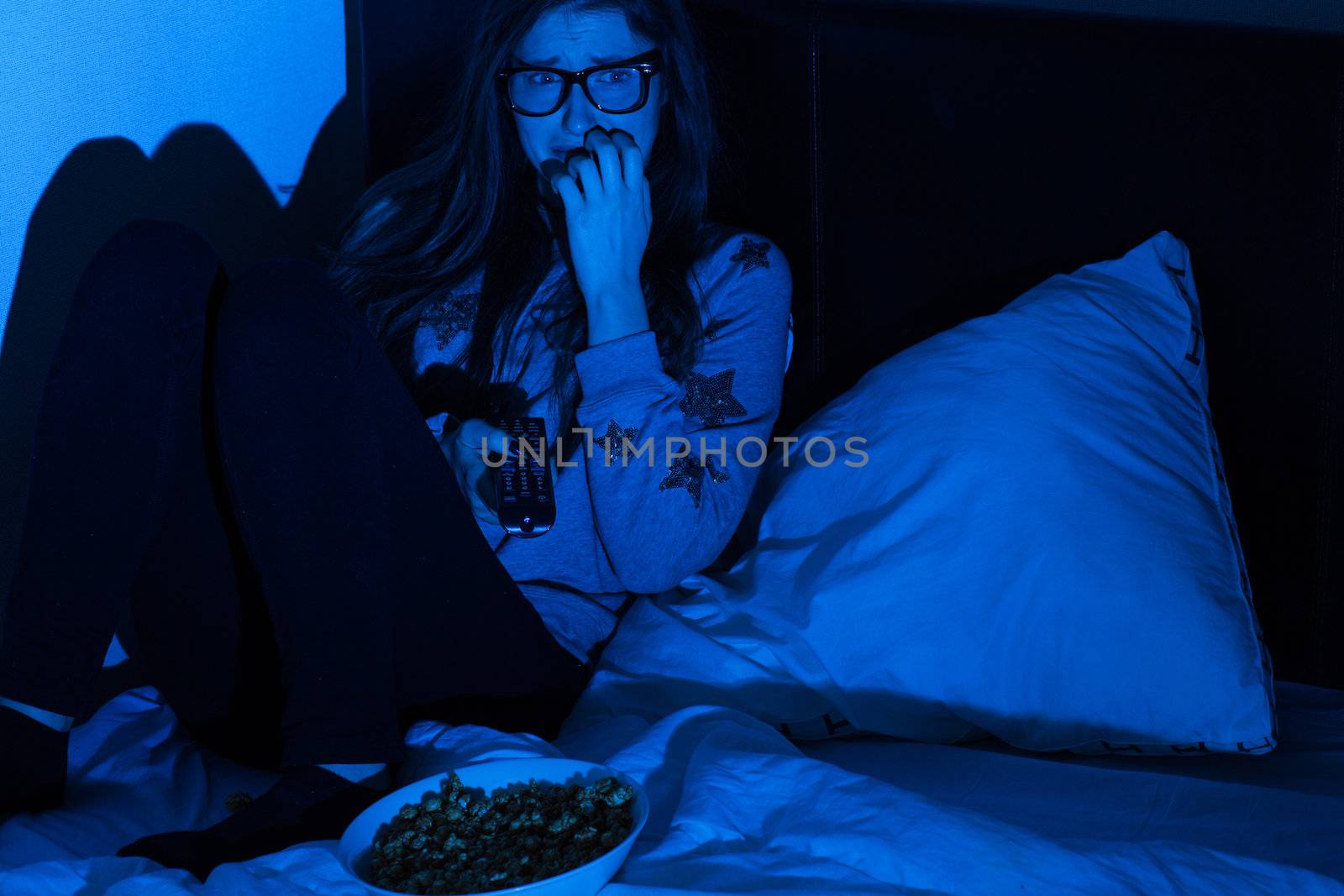 Young woman watching scary movie by rufatjumali