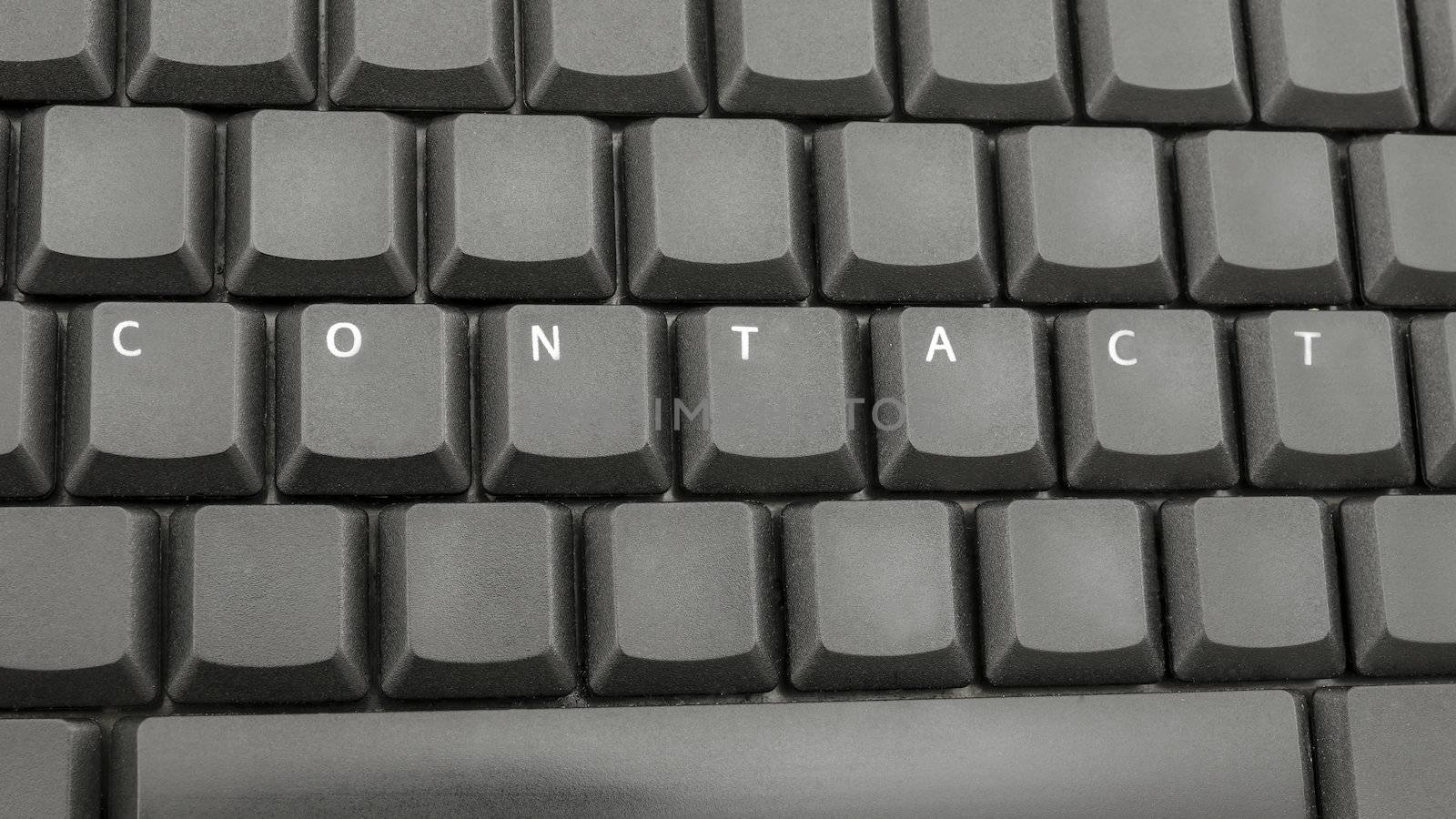 Top view of word contact spelled on computer keyboard.